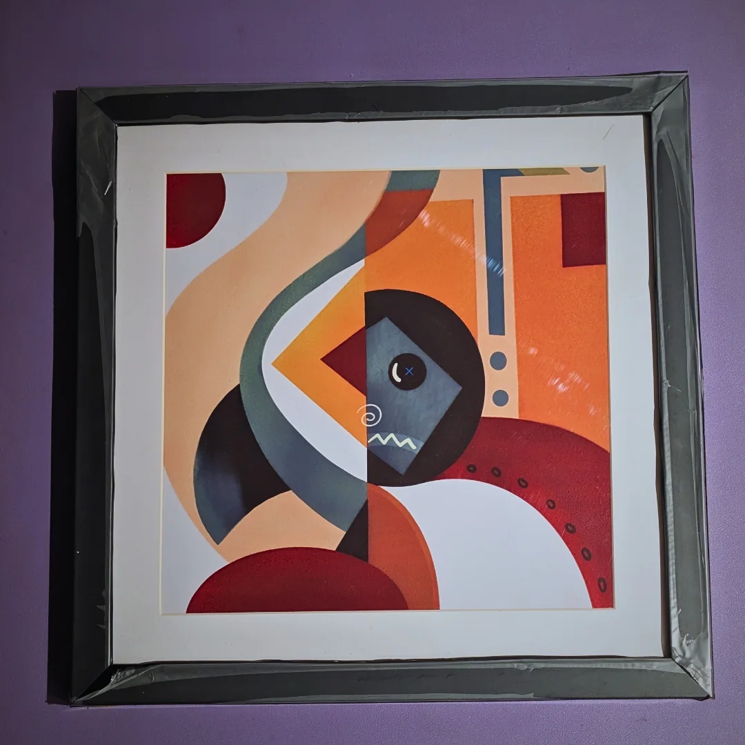 Framed abstract geometric artwork in warm orange, red, cream and blue