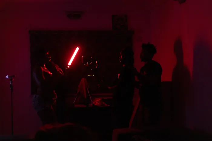 Camera and lighting team preparing a red-lit interior scene